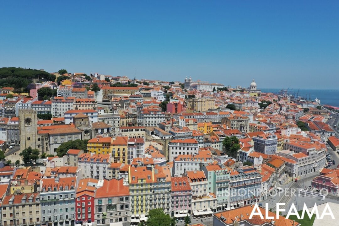 Alfama 13 View of the colorful buildings of Alfama positioned in an amphitheater overlooking the river, with the labyrinthine streets... below we see the Casa dos Bicos, on the left side we see the Sé Cathedral, at the top left are the pine trees of the Castelo de São Jorge. On the right we can see the church of São Vicente de Fora, the national pantheon and the Santa Apolônia station with the cruise port
