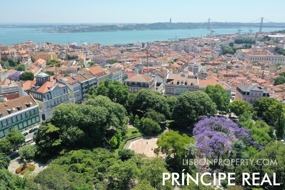 Príncipe Real 8 View of Principe Real garden square located at the top of the hill in the Santo António and Misericórdia parishes. The view shows the facade of buildings in the Misericórdia area with French influence from the Napoleonic period, the Tagus River, and the city of Almada on the south bank, with Cristo Rei and the 25 de Abril Bridge