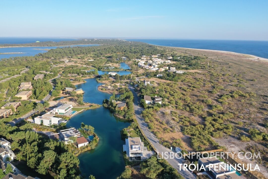 Photo of the Tróia Peninsula, featuring the luxury homes area around the lake, the Tróia Golf Course, the Sado River on the left, the Atlantic Ocean on the right, and a strip of natural, wild beaches stretching south to Comporta.